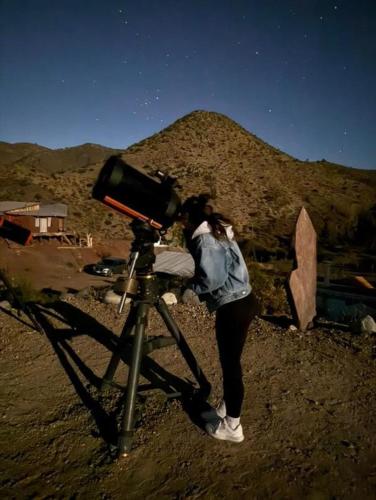 a woman standing next to a bike in the desert at Alojamiento y Refugio Cósmico Torreon in Comunidad Campo de Ahumada