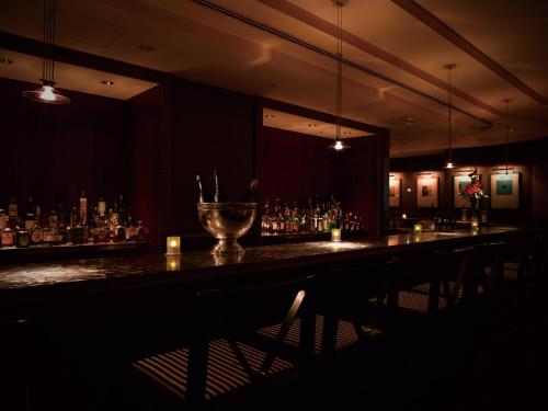 a bar with a long counter in a dark room at Kobe Bay Sheraton Hotel & Towers in Kobe