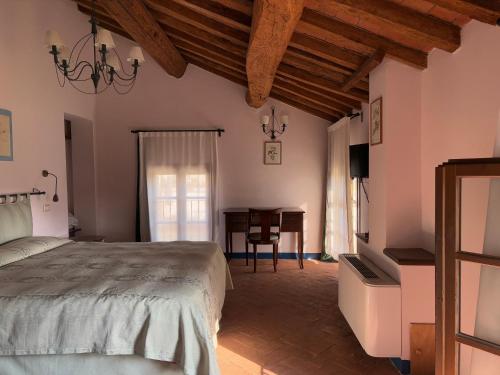 a bedroom with a bed and a desk and a table at Agriturismo Ca' Guerriera in Sustinente