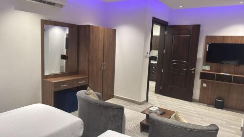 a hotel room with a bed and a television at شقق زهرة النزلاء المخدومة الخرج in Al Kharj