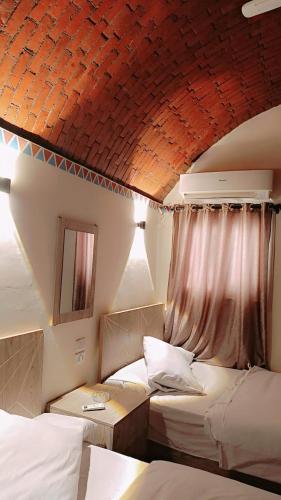 a bedroom with two beds and a red ceiling at Kenzy House Abu Simbel in Abu Simbel