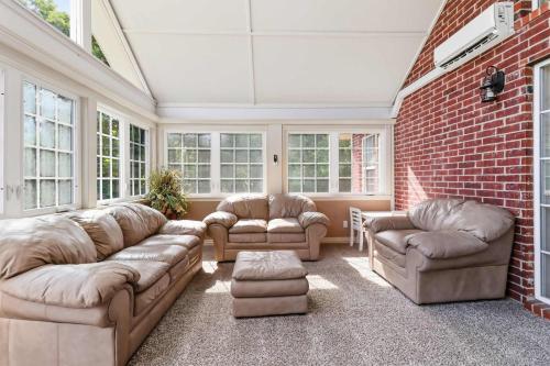 a living room with couches and a brick wall at Casa Oasis Extra Large home centrally located in Springdale
