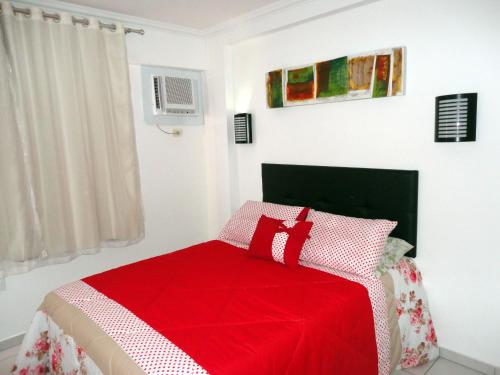 1 dormitorio con 1 cama con manta roja y blanca en Apartamento Beira Mar Maceió, en Maceió