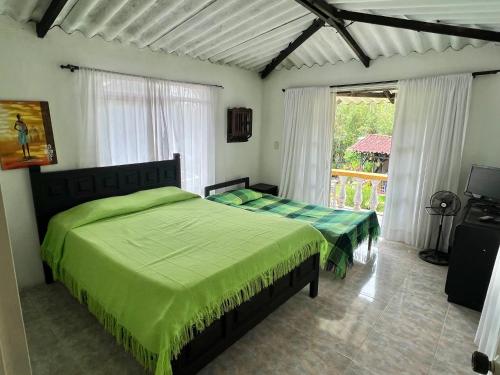 a bedroom with two beds and a balcony at Casa de campo los anturios in La Tebaida