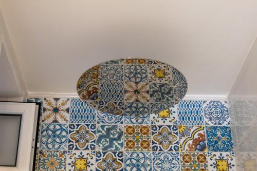 a bathroom with mosaics on the ceilings of a room at Oikos Terrasini in Terrasini