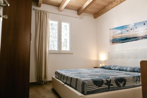 a bedroom with a bed in a room with a window at Oikos Terrasini in Terrasini
