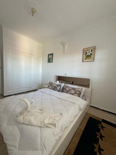 a bedroom with a large white bed with a bird on it at Maison front de mer in El Jadida