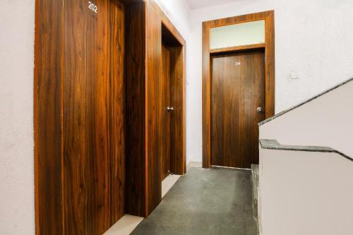 a hallway with two wooden doors and a staircase at Hotel O Galaxy Near INOX in Yeraoda