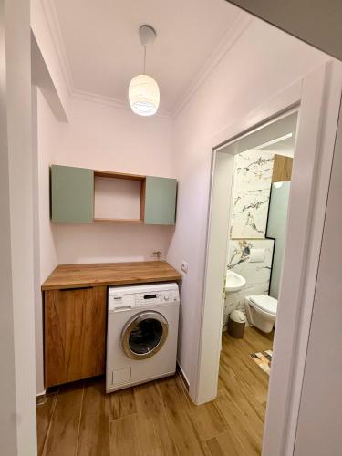 a laundry room with a washer and a bathroom at Aisha Apartment in Berat