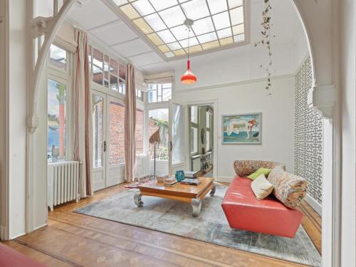 a living room with a red couch and a table at La Maison Bleue Ronse in Ronse