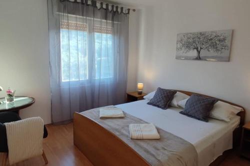 a bedroom with a bed with two towels on it at Apartments with parking space Slatine, Ciovo - 16731 in Slatine