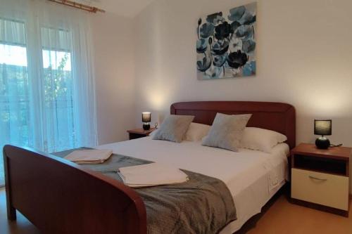 a bedroom with a large bed and a window at Apartments with parking space Slatine, Ciovo - 16732 in Slatine