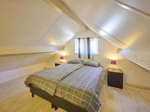 a bedroom with a large bed in a attic at Scheldeoord 54 in Baarland