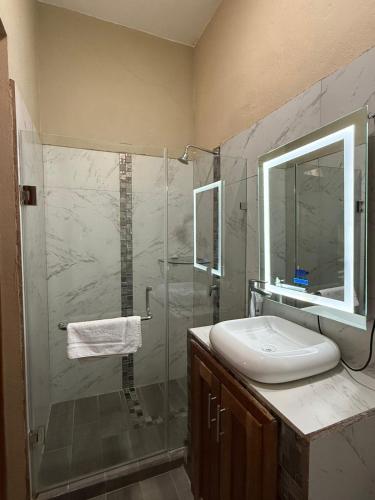 a bathroom with a shower and a sink and a mirror at Maximos Petit Hotel in Flores