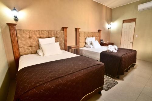 a hotel room with two beds and a table at Maximos Petit Hotel in Flores