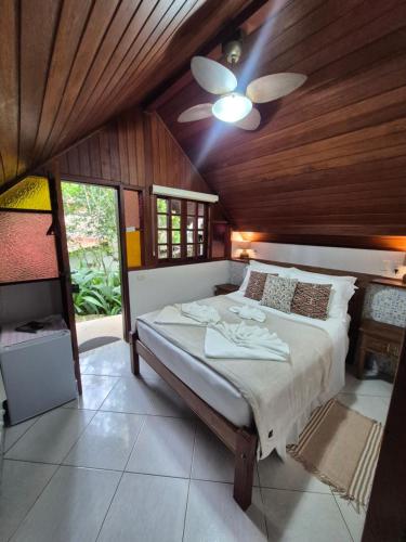 a bedroom with a bed and a ceiling fan at Aratinga Inn in Abraão