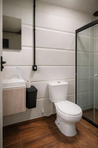 a bathroom with a toilet and a sink and a shower at Container Loft Com Área de Churrasqueira Privativa in Piçarras