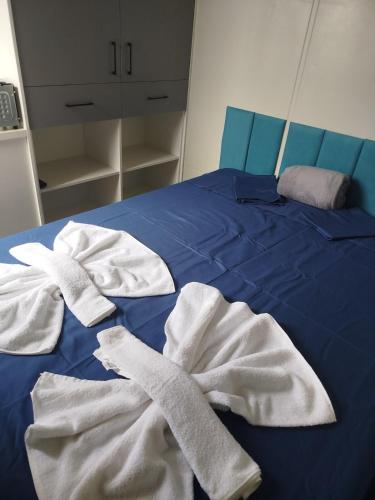a blue bed with white towels on it at Container Loft Com Área de Churrasqueira Privativa in Piçarras