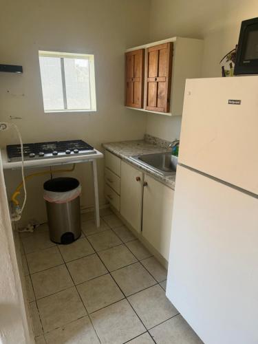 a kitchen with a white refrigerator and a sink at Downtown Purple Apartment in Phoenix