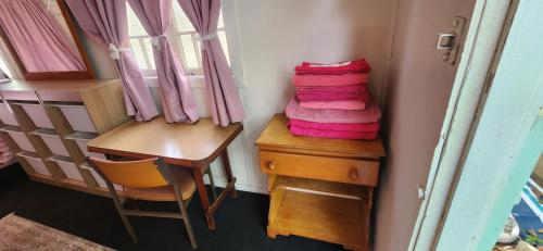 a room with a stack of pink towels and a desk at Meyenburg Family Room in Mount Morgan