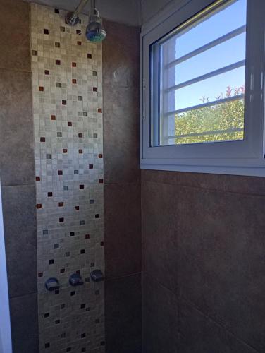 a bathroom with a shower and a window at Loft Las Acacias in Potrero de los Funes