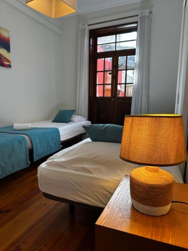 a room with two beds and a table with a lamp at Best House Center - with Garage in Porto