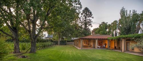 a house with a green yard with a building at Verde Oliva Casa de Huéspedes in Maipú