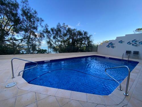 a swimming pool with blue water on a patio at High Level with Ocean Views Everywhere in Buddina