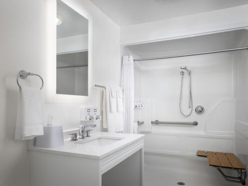 a white bathroom with a sink and a shower at Ashworth by the Sea in Hampton