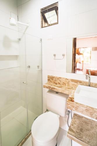 a bathroom with a toilet and a sink and a shower at Tapirandú Pousada in Morro de São Paulo