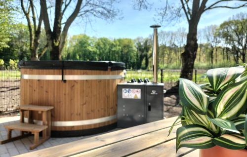 a wooden hot tub and a bench and trees at 5 Bedroom Luxurious Home In Afferden in Afferden