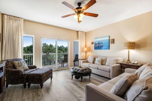 a living room with a couch and a ceiling fan at Beachside Resort Condo with Pools and Tennis in Destin