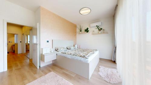 a white bedroom with a bed in a room at Vila Golf & Relax, Hrubá Borša in Hrubá Borša