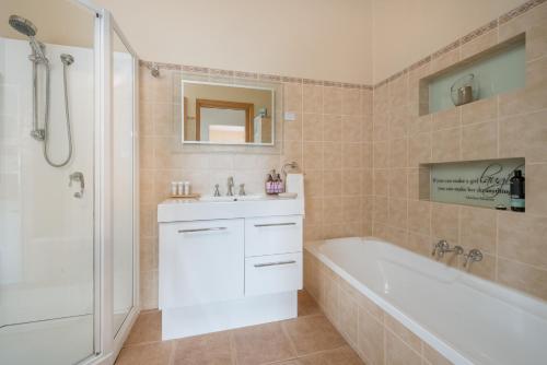 a bathroom with a white tub and a sink and a bath tub at Jones On Wilson Boutique B&B in Burnie