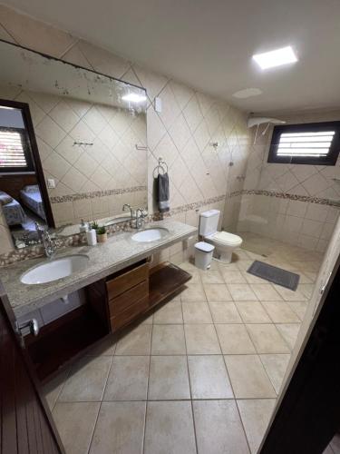 a bathroom with two sinks and a toilet at Casa Brisa do Mar in Pipa