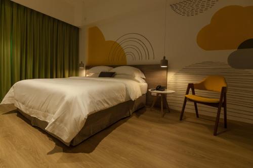a bedroom with a large bed and a chair at Buluba in Yuanshan