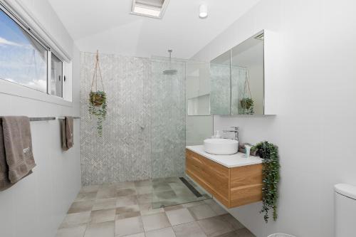 a white bathroom with a sink and a shower at Lakeshore Serenity @ Warners Bay in Warners Bay