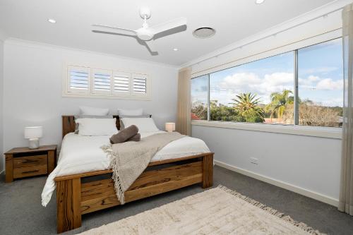 a bedroom with a bed and a large window at Lakeshore Serenity @ Warners Bay in Warners Bay