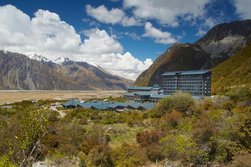 a building in the middle of a valley with mountains at The Hermitage Hotel Mt Cook in Mount Cook Village