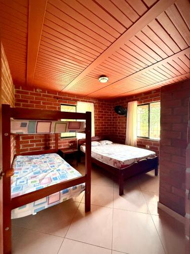 a room with two bunk beds and a brick wall at El Faro de los Abuelos in San Bernardo del Viento