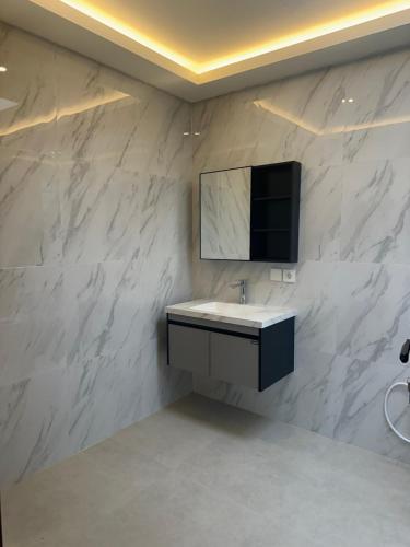 a bathroom with a sink and a tv on a wall at Adi Villa in Darmasaba