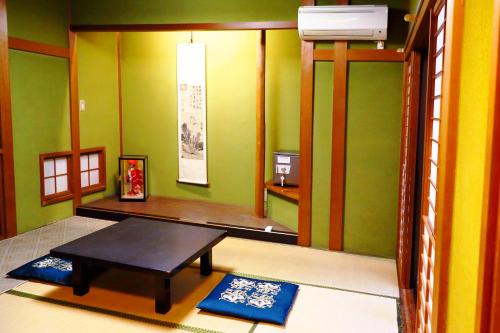 a room with a table and two mats in it at Ryokan Karasawa in Kanazawa