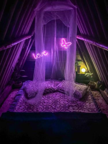 a bedroom with a bed with neon lights in it at Chalé Moon - Vale do ribeira in Juquiá