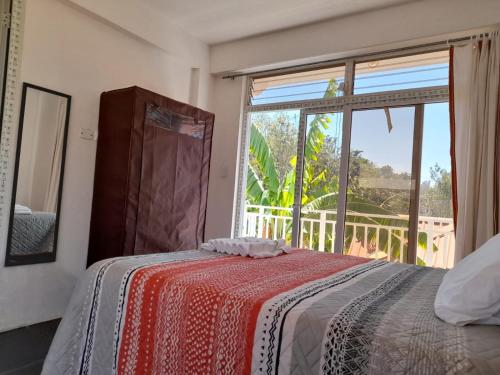 a bedroom with a bed and a large window at Residencias Los Hasses in Santiago Atitlán