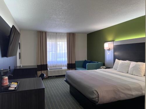 a hotel room with a large bed and a chair at Quality Inn Seekonk-Providence in Seekonk