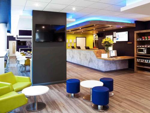 a lobby with tables and chairs and a counter at ibis budget Belfast City Centre in Belfast