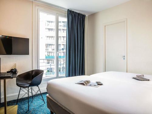 a hotel room with a bed and a chair and a window at ibis Styles Paris 15 Lecourbe in Paris