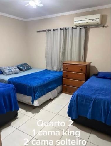 a bedroom with two beds and a dresser in it at Ice pool house in São Vicente