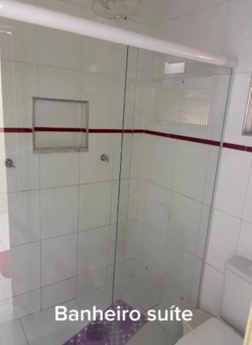 a shower with a glass door in a bathroom at Ice pool house in São Vicente