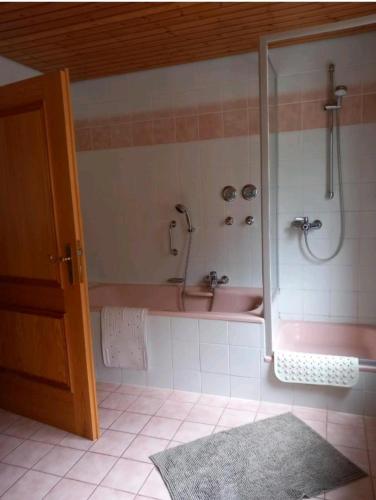 a bathroom with a pink tub and a sink at Nähe Nationalpark in Baiersbronn